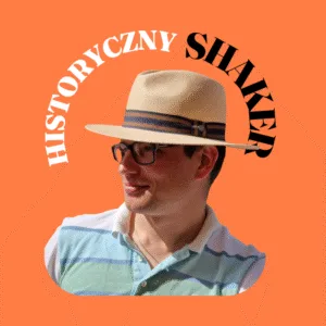Młody mężczyzna na pomarańczowym tle. Zdjęcie portretowe, ma na głowie kapelusz, a na nosie okulary. Nad nim napis jego firmy i kanału "Historyczny Shaker"